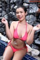 A woman in a pink bikini sitting in a pool.