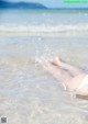 A woman in a white bikini laying in the water.