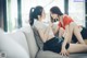 Two young women sitting on a couch talking.