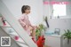 A woman in a pink suit sitting on a white staircase.