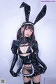 A woman in a black bunny costume posing for a picture.