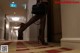 A woman in high heels is walking down a hallway.