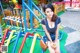 A woman sitting on top of a playground holding a drink.