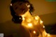 A naked woman with a string of lights around her neck.