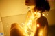 A naked woman sitting on a bed covered in lights.