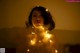 A woman with a string of lights around her neck.