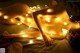 A naked woman laying on a bed covered in lights.