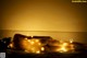 A naked woman laying on a bed covered in lights.