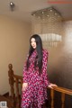 A woman in a red and blue dress standing on a staircase.