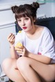 A woman sitting on a couch eating a bowl of food.