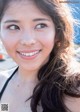 A woman with long brown hair smiles at the camera.